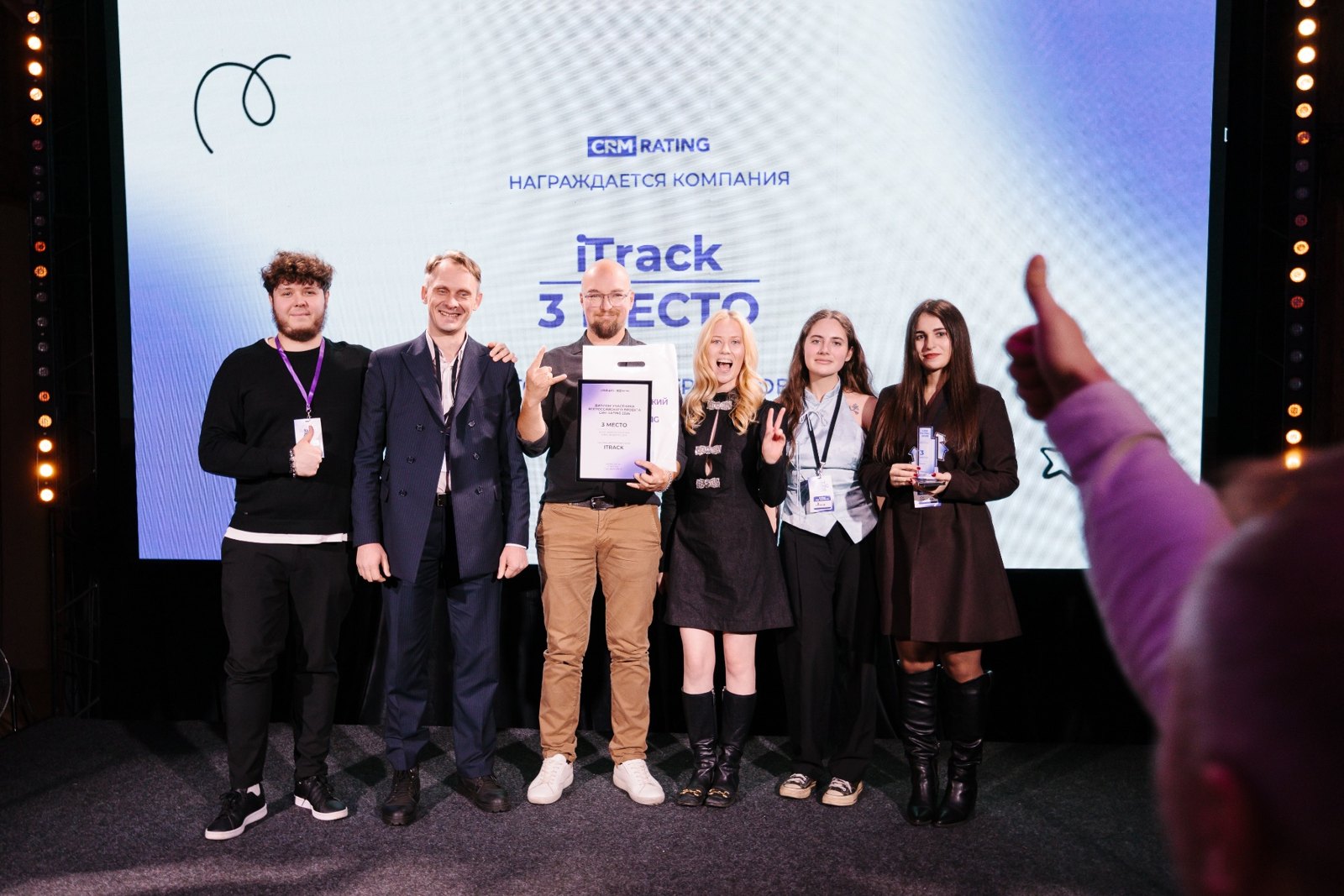 Представители iTrack на сцене церемонии CRM RATING 2026, на экране — третье место компании